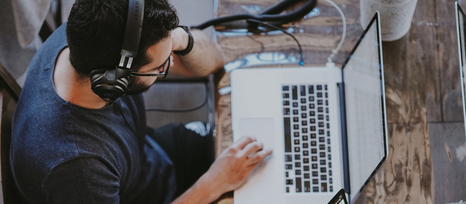 Person wearing a headset working across multiple connected laptops